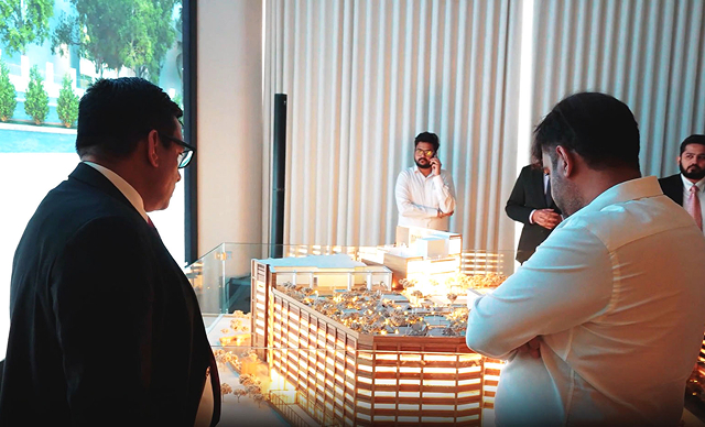 Buyers review a physical scale model in a sales gallery