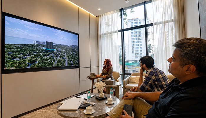 Group of clients navigating an interactive 3D property walkthrough on a touchscreen