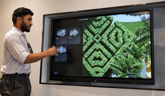 Sales team exploring landscape planning on 3D property display