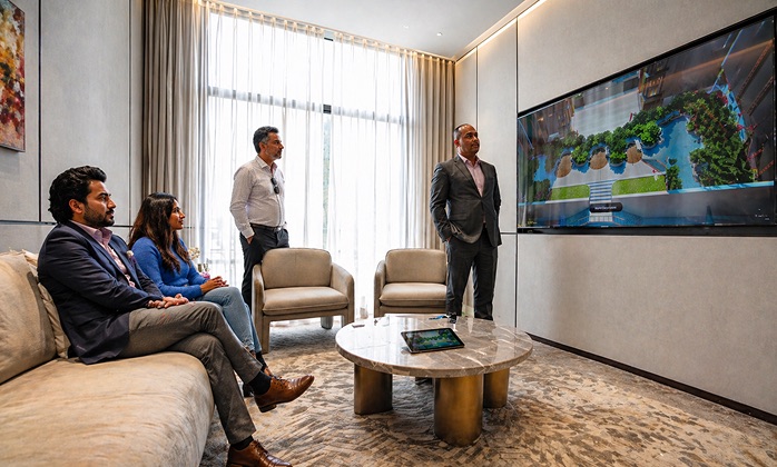 Sales team presenting a full property layout and amenities on a large LED screen